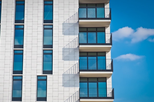 gray apartment building with blue sky background